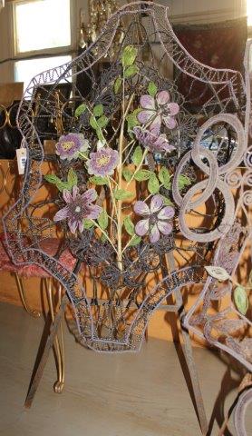 An oval beaded floral display on tripod stand
